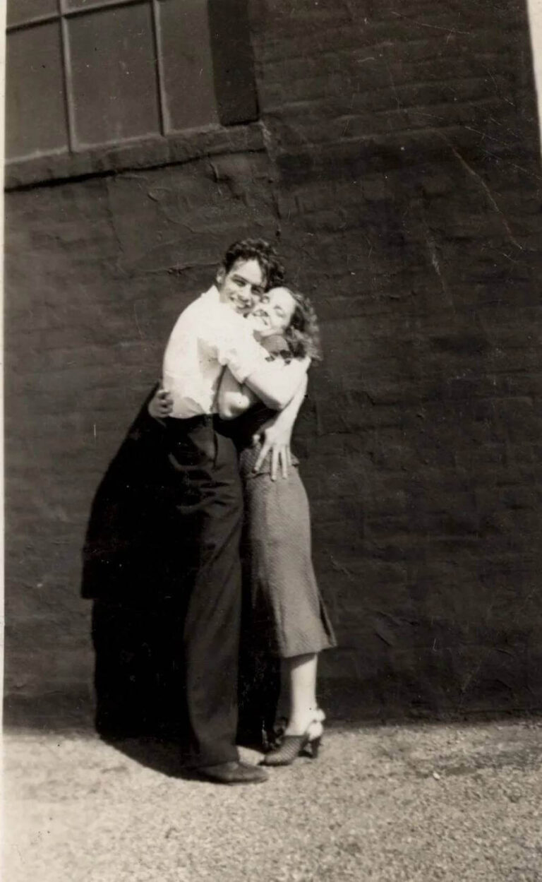 black white photo of a young couple in love, smiling and holding each other